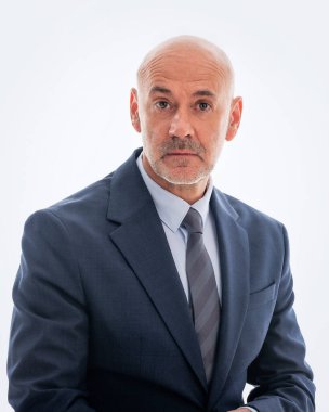 Orta yaşlı işadamı takım elbise giyip izole edilmiş arka planda kravat takıyor. Beyaz arka planda oturan kendine güvenen adam kameraya hayret içinde bakıyor. Boşluğu kopyala.