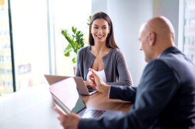 İş arkadaşları toplantıda dizüstü bilgisayar kullanıyor. Takım çalışması. Modern bir ofiste iş adamları toplantı sırasında tartışıyor..