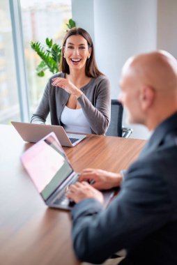 İş arkadaşları toplantıda dizüstü bilgisayar kullanıyor. Takım çalışması. Modern bir ofiste iş adamları toplantı sırasında tartışıyor..