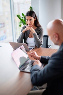 İş arkadaşları toplantıda dizüstü bilgisayar kullanıyor. Takım çalışması. Modern bir ofiste iş adamları toplantı sırasında tartışıyor..