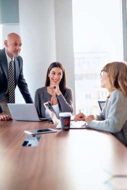 İş arkadaşları toplantıda dizüstü bilgisayar kullanıyor. Takım çalışması. Modern bir ofiste iş adamları toplantı sırasında tartışıyor..