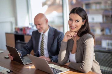 İş arkadaşları toplantıda dizüstü bilgisayar kullanıyor. Takım çalışması. Modern bir ofiste iş adamları toplantı sırasında tartışıyor..