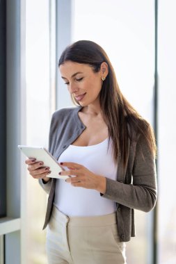 Ofiste elinde dijital tabletle duran bir iş kadını. Modern bir ofiste çalışan profesyonel bir kadın..