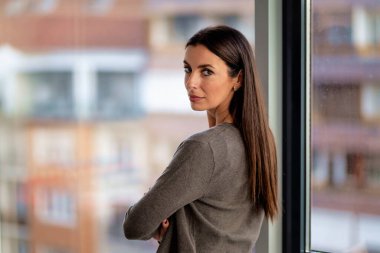 Modern bir ofiste kameraya bakan çekici bir iş kadını. İş kıyafeti giyen orta yaşlı bir kadın..  