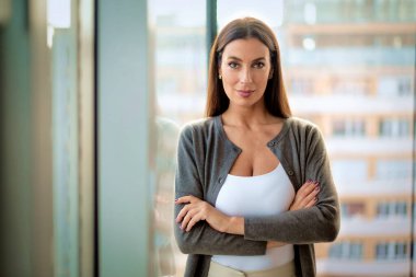 Modern bir ofiste kameraya gülümseyen çekici bir iş kadını. İş kıyafeti giyen orta yaşlı bir kadın.. 