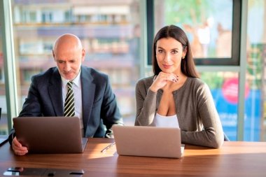 İş arkadaşları toplantıda dizüstü bilgisayar kullanıyor. Takım çalışması. Modern bir ofiste iş adamları toplantı sırasında tartışıyor..