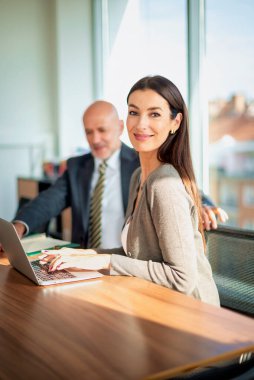 İş arkadaşları toplantıda dizüstü bilgisayar kullanıyor. Takım çalışması. Modern bir ofiste iş adamları toplantı sırasında tartışıyor..