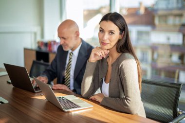 İş arkadaşları toplantıda dizüstü bilgisayar kullanıyor. Takım çalışması. Modern bir ofiste iş adamları toplantı sırasında tartışıyor..