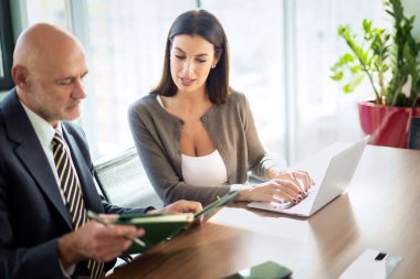 İş arkadaşları toplantıda dizüstü bilgisayar kullanıyor. Takım çalışması. Modern bir ofiste iş adamları toplantı sırasında tartışıyor..