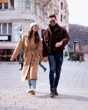Şehirde yürüyen ve kış günü eğlenen olgun bir çift. Orta yaşlı çift romantik bir anı paylaşıyor. Tam boy çekim. 