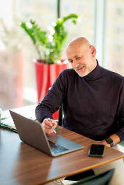 Kafkas işadamı büro masasında oturuyor ve not defteri kullanıyor. Modern bir ofiste çalışan profesyonel bir erkek.. 