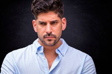 Kızgın suratlı bir adamın izole edilmiş arka planda düşünceli bir şekilde çekilmiş bir fotoğrafı. Gündelik kıyafetler giyen kendinden emin bir erkek. Boşluğu kopyala. 
