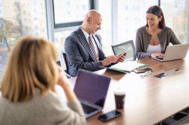 İş arkadaşları toplantıda dizüstü bilgisayar kullanıyor. Takım çalışması. Modern bir ofiste iş adamları toplantı sırasında tartışıyor..