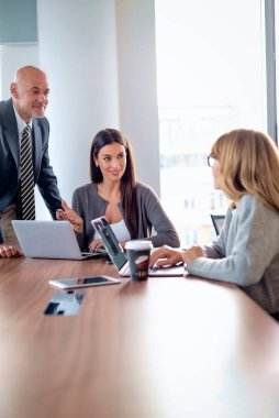 İş arkadaşları toplantıda dizüstü bilgisayar kullanıyor. Takım çalışması. Modern bir ofiste iş adamları toplantı sırasında tartışıyor..