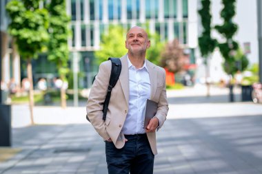 İş adamı elinde dizüstü bilgisayarla işe gidiyor. Gündelik kıyafetler giyen profesyonel bir erkek.. 