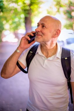 Şehirde dolaşan sıradan bir adam. Orta yaşlı iş adamı sırt çantası takıyor ve telefonla konuşuyor.. 