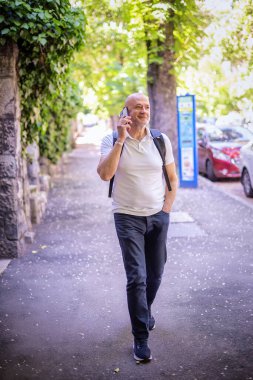 Şehirde dolaşan sıradan bir adam. Orta yaşlı iş adamı sırt çantası takıyor ve telefonda konuşuyor. Tam menzil..