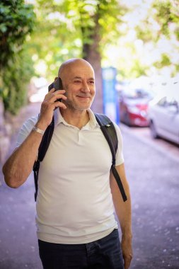 Şehirde dolaşan sıradan bir adam. Orta yaşlı iş adamı sırt çantası takıyor ve telefonla konuşuyor.. 