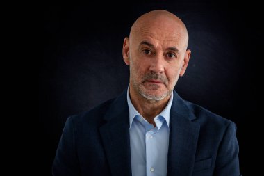 Orta yaşlı bir adamın izole edilmiş arka planda çekilmiş bir fotoğrafı. Kendine güvenen erkek takım elbiseli ve kameraya bakıyor. Boşluğu kopyala.