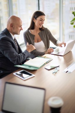 Bir grup iş arkadaşı masada oturuyor ve iş toplantısı yapıyorlar. Orta yaşlı iş adamları dizüstü bilgisayar kullanıyor ve tartışıyorlardı. Takım çalışması.. 