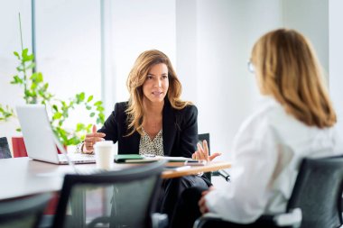 Bir grup iş adamı masa başında çalışıyor. Modern bir ofiste takım çalışması. İş toplantısı.