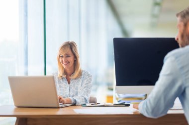 Ofiste oturan ve çalışan iş adamları. İş kadını ve iş adamı toplantı yapıyor. Takım çalışması..
