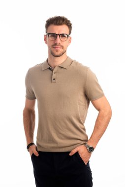 İzole edilmiş beyaz arka plana karşı duran yakışıklı bir gencin stüdyo fotoğrafı. Kendine güvenen erkek iş kıyafeti giyiyor ve kameraya bakıyor. Uzayı kopyala İzole edilmiş arkaplan.