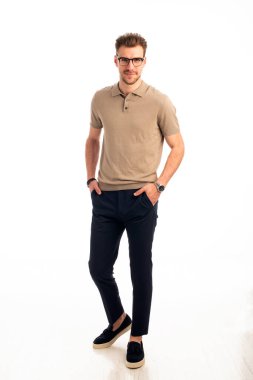 İzole edilmiş beyaz arka plana karşı duran yakışıklı bir gencin stüdyo fotoğrafı. Kendine güvenen erkek iş kıyafeti giyiyor ve kameraya bakıyor. Uzayı kopyala İzole edilmiş arkaplan.