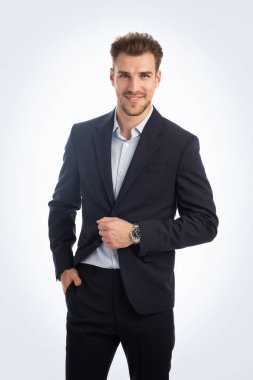 İzole edilmiş beyaz arka plana karşı duran yakışıklı bir gencin stüdyo fotoğrafı. Kendine güvenen erkek takım elbiseli ve kameraya bakıyor. Uzayı kopyala İzole edilmiş arkaplan. 
