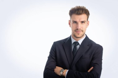 İzole edilmiş beyaz arka plana karşı duran yakışıklı bir gencin stüdyo fotoğrafı. Kendine güvenen erkek takım elbiseli ve kameraya bakıyor. Uzayı kopyala İzole edilmiş arkaplan. 