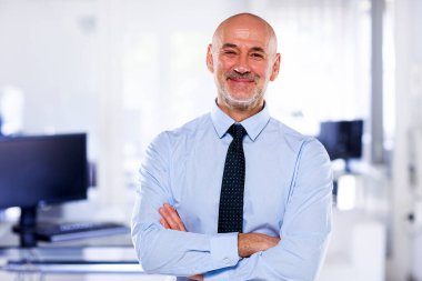 Modern işyerindeki kıdemli işadamının portresi. Gömlek ve kravat takan ve kameraya bakan kendine güvenen profesyonel bir adam.. 