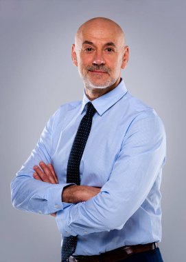 Tecrit edilmiş arka planda duran son sınıf öğrencisinin stüdyo portresi. Uzayı kopyala Tişört ve kravat giyen kendinden emin bir erkek.. 