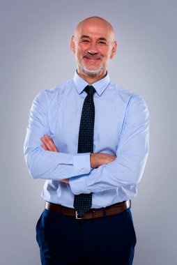 Tecrit edilmiş arka planda duran son sınıf öğrencisinin stüdyo portresi. Uzayı kopyala Tişört ve kravat giyen kendinden emin bir erkek.. 