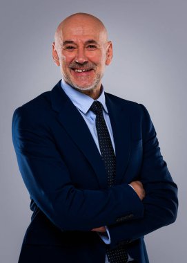 Tecrit edilmiş arka planda duran yaşlı adamın stüdyo portresi. Uzayı kopyala Kendine güvenen erkek takım elbiseli ve kameraya gülümsüyor..