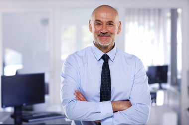 Modern işyerindeki kıdemli işadamının portresi. Gömlek ve kravat takan ve kameraya bakan kendine güvenen profesyonel bir adam.. 