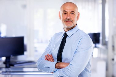 Modern işyerindeki kıdemli işadamının portresi. Gömlek ve kravat takan ve kameraya bakan kendine güvenen profesyonel bir adam.. 