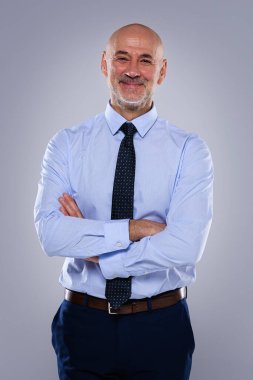 Tecrit edilmiş arka planda duran son sınıf öğrencisinin stüdyo portresi. Uzayı kopyala Tişört ve kravat giyen kendinden emin bir erkek.. 