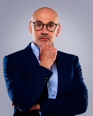 Tecrit edilmiş arka planda duran yaşlı adamın stüdyo portresi. Uzayı kopyala Kendine güvenen erkek takım elbiseli ve düşünceli görünüyor..