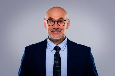 Tecrit edilmiş arka planda duran yaşlı adamın stüdyo portresi. Uzayı kopyala Kendine güvenen erkek takım elbiseli ve kameraya gülümsüyor..