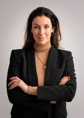 Orta yaşlı çekici bir iş kadınının gülümseyen ve kameraya bakan bir stüdyo fotoğrafı. Esmer, kadın balıkçı yaka kazak ve ceket giyerken izole arka planda dikiliyor. Boşluğu kopyala. 