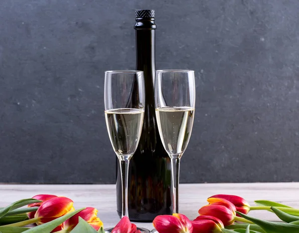 stock image glasses of champagne and roses on a dark background.