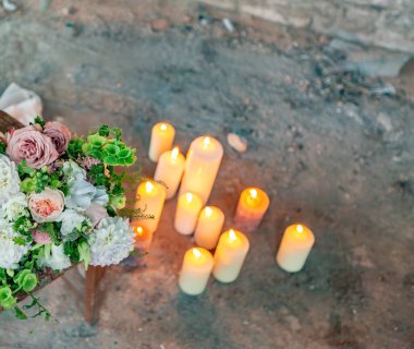 Güzel bir çiçek buketi ve ahşap arka planda mumlar.