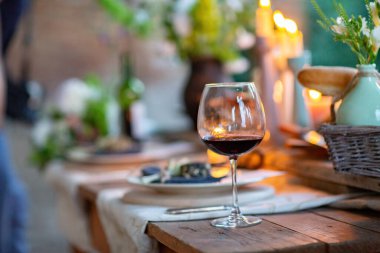 şarap kadehleri ve kırmızı ve beyaz çiçekli masa