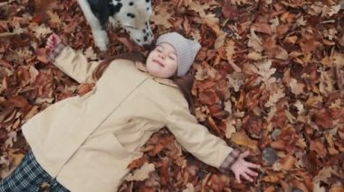 Kız ormanda dökülen yapraklara uzanır.