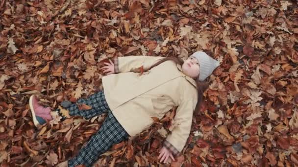 Девушка Лежит Опавших Листьях Лесу — стоковое видео