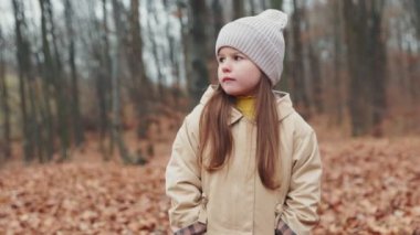 Sonbahar ormanındaki küçük bir kızın portresi.