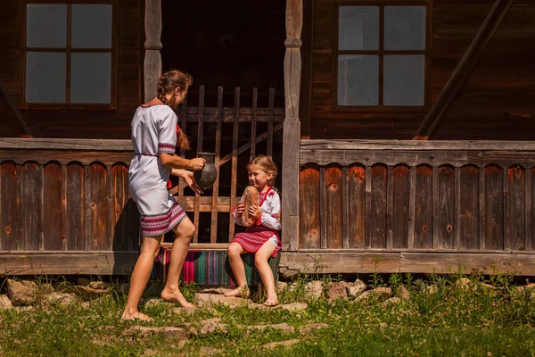 身着乌克兰民族服装的母女来到了房子的门口 — 图库照片