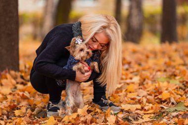 girl with her little dog in autumn park