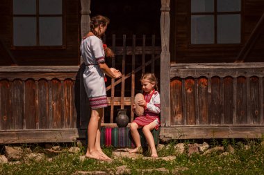 Ukrayna halkının anne ve kızı evin eşiğinde giyiniyor..