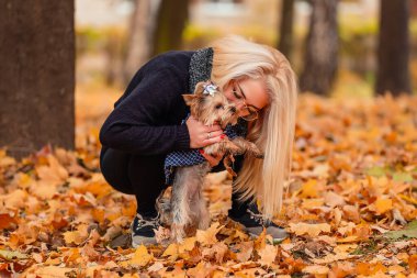 girl with her little dog in autumn park
